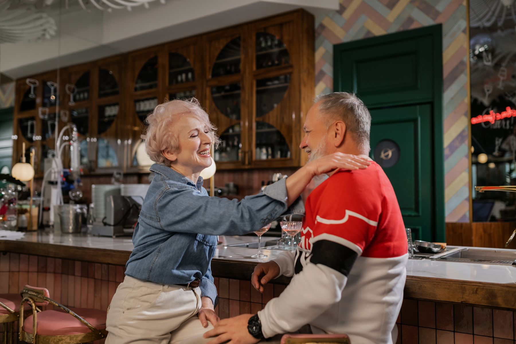 Casal de idosos dançando e rindo em um bar
